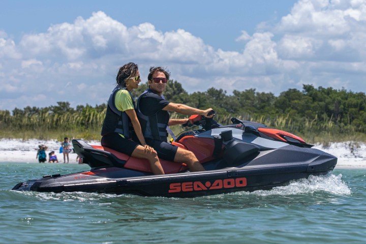 a group of people riding on the back of a boat in the water